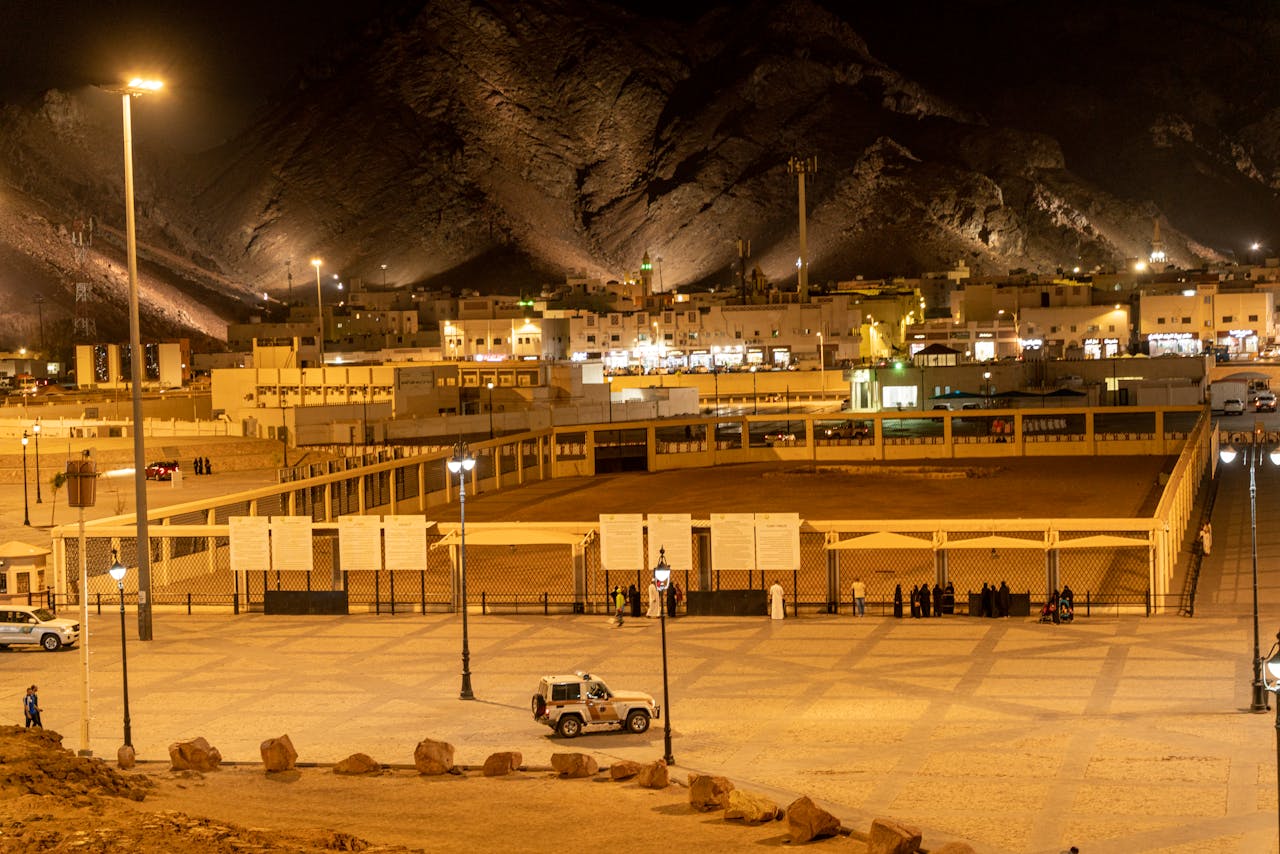 Illuminated Medina landscape with mountains and city lights at night.